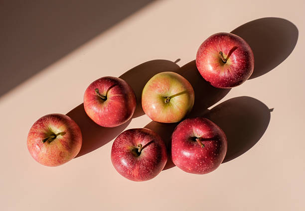 istock green and red apples scattered on beige background, hard shadow 2208320722