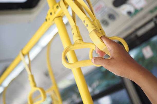 istock woman hand holding a gray handle on a bus 2208322874