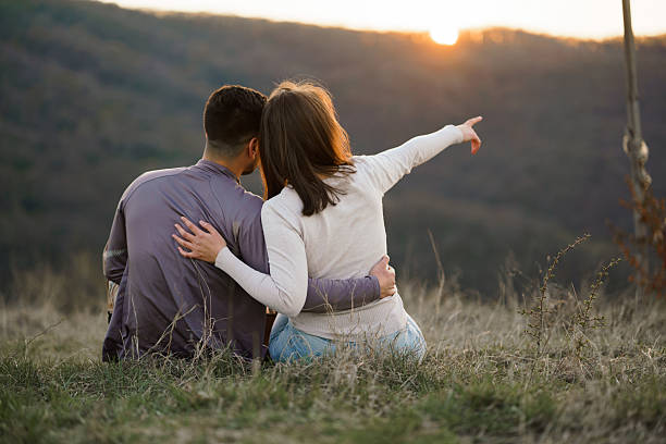 istock Woman points her finger into the distance while sitting with a man on a mountain 2208323149