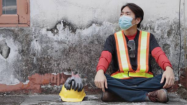 Zoom View Blue Collar Worker Take Off Safety Helmet and Gloves on Break Time. Professional Occupation Working in Plant