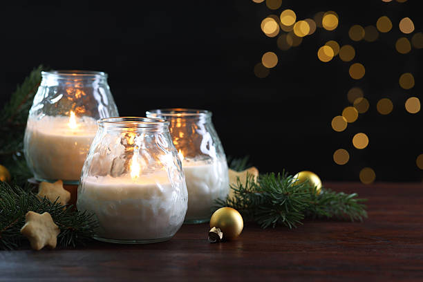 istock Burning candles, baubles and fir tree branches on wooden table, closeup. Space for text 2208326189