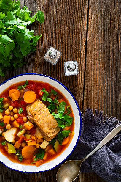 istock Fresh vegetable soup with chickpeas and meat on wooden table 2208326302