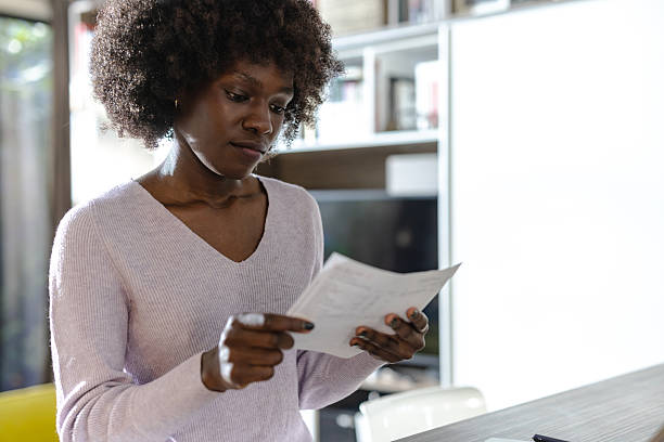 istock Focused woman reviewing documents at home 2208326390
