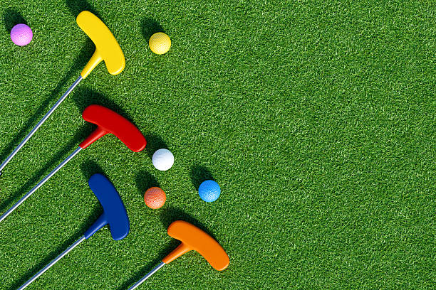 istock Colorful putters and golf balls on green grass for fun play. 3d rendering 2208328410