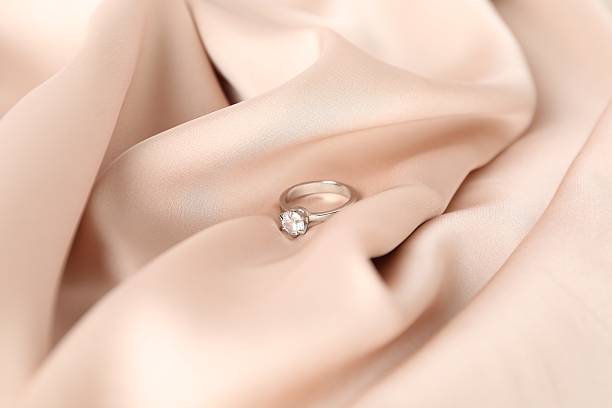 istock Beautiful ring with gemstone on beige fabric, closeup 2208328694