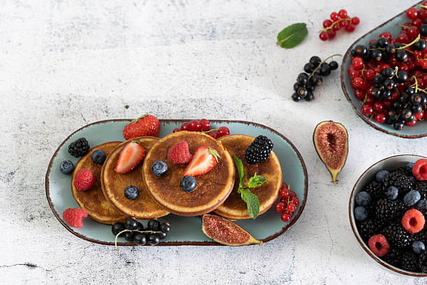 istock Fluffy pancakes adorned by colorful berries 2208330494