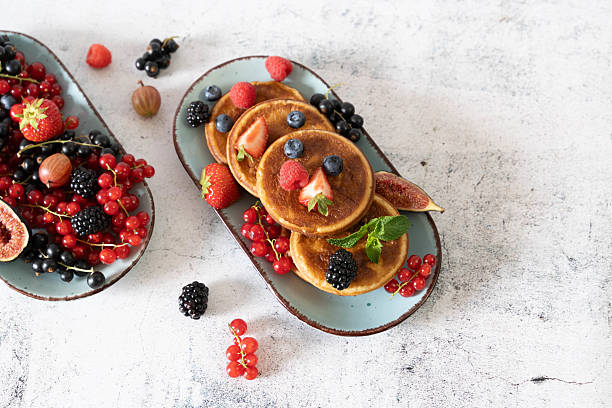 istock Fluffy pancakes adorned by colorful berries 2208330515