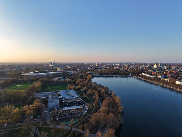 Stunning aerial view capturing a vibrant city by the river during sunset, showcasing parks and architecture. Maschsee Hannover