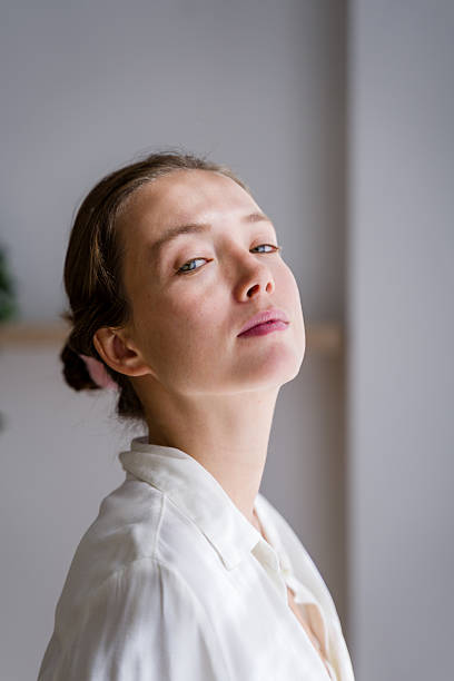 istock Young woman with white shirt tilting her head and looking at camera 2208339168