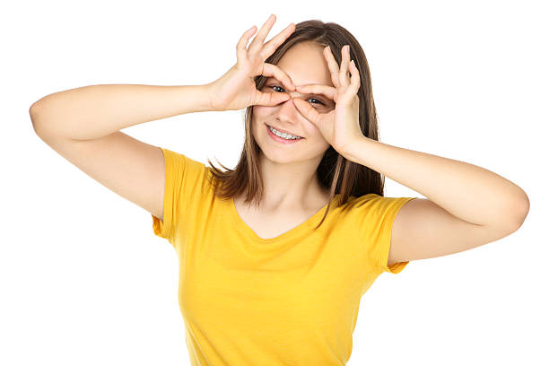 istock Young girl showing eyes by hands on white background 2208340281