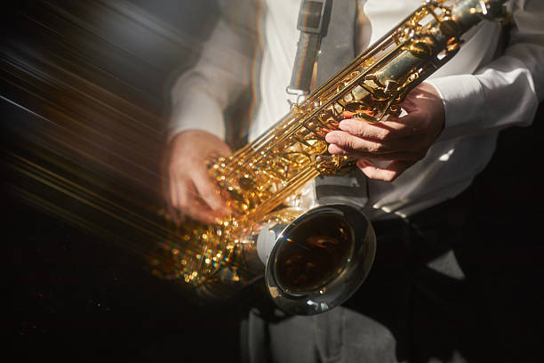 istock Male Musician Playing Jazz on Shiny Saxophone under Spotlight on Stage 2208341059