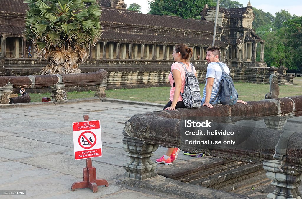 Stone Railing Sitting Two Caucasian Tourists Sit On The Stone Railing Right Next To A Red ...