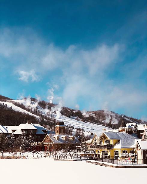 istock Charming snowy village with ski slopes under blue sky. 2208341843