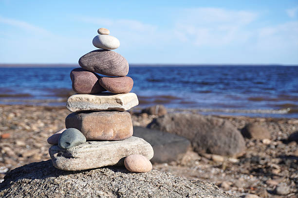Stone cairn built on a rock on the lakeshore representing balance, harmony and peace
