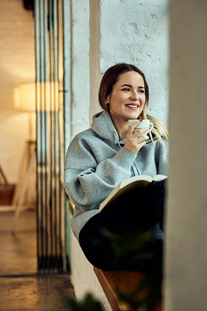 istock Woman Relaxing with Coffee and Book in Cozy Indoor Setting 2208343939