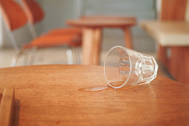 istock A glass has been spilled on a wooden table inside a modern cafe environment 2208345264