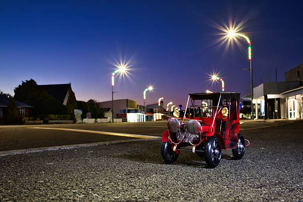 Red model vintage car at the main street of Foxton, New Zealand, with a dawn sky in the background.