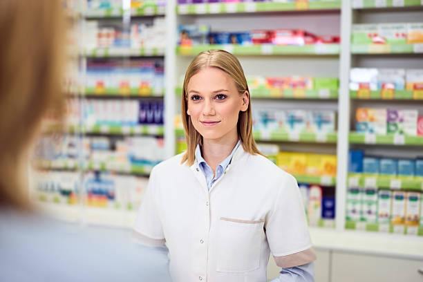 istock Smiling Pharmacist Handling Customers in a Modern Pharmacy Setting with Shelves 2208345482