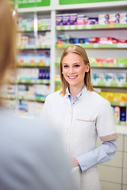 istock Smiling Pharmacist Communicating With Customer in a Modern Pharmacy Interior 2208345495