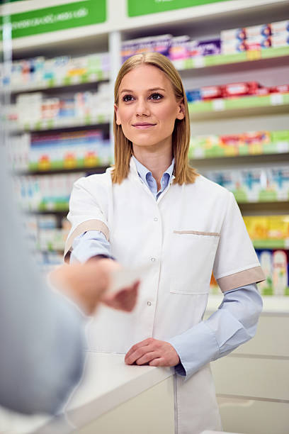 istock Friendly Pharmacist Assisting a Customer at The Pharmacy Counter 2208345496