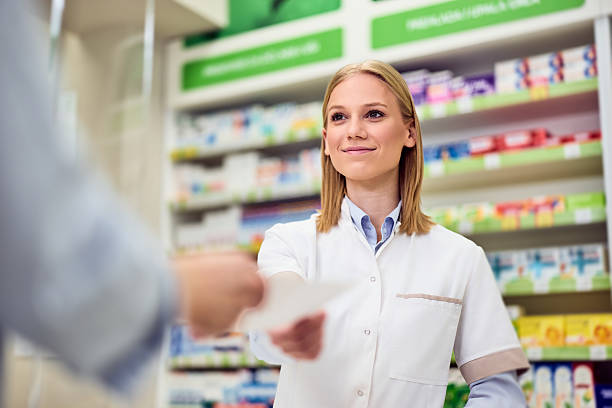 istock Smiling Pharmacist Assisting Customer in a Modern Well-Stocked Pharmacy 2208345498