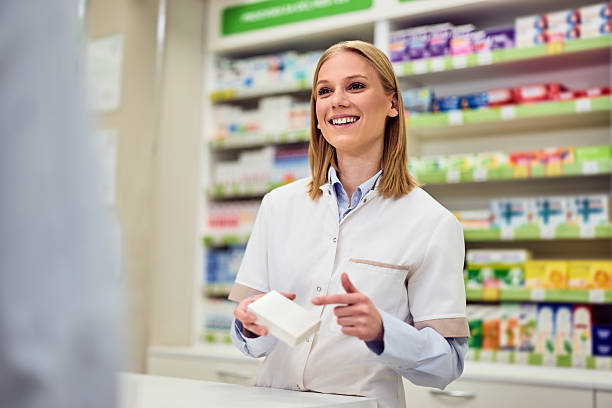 istock Smiling Pharmacist Assisting a Customer in a Bright Pharmacy Environment 2208345501