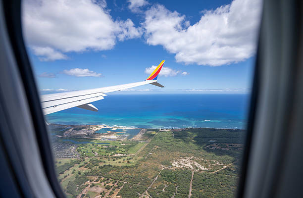 Hawaii  United States June27, 2024:  stunning photograph captures the breathtaking aerial view of the approach to Honolulu, taken from a Southwest Airlines aircraft. The image showcases the vibrant blue of the Pacific Ocean, the lush landscapes of the Hawaiian Islands, and the distinctive wing of the Southwest plane, creating a sense of anticipation for the island adventure ahead.