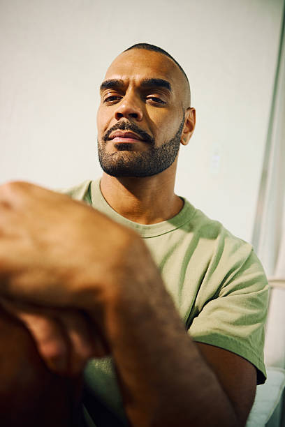 istock Young aboriginal australian man sitting and looking at camera 2208354252
