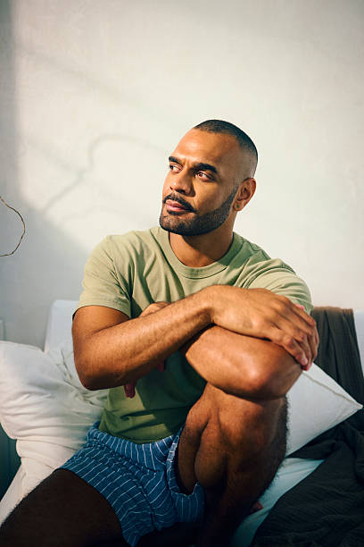 istock Young aboriginal australian man relaxing in bed in the morning 2208354299