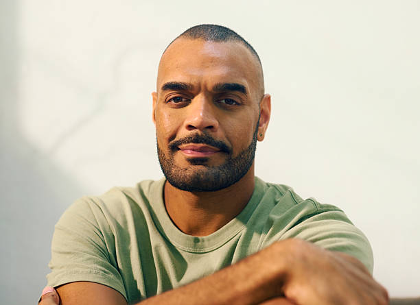 istock Young aboriginal australian man sitting thoughtfully on sofa in morning light 2208354315