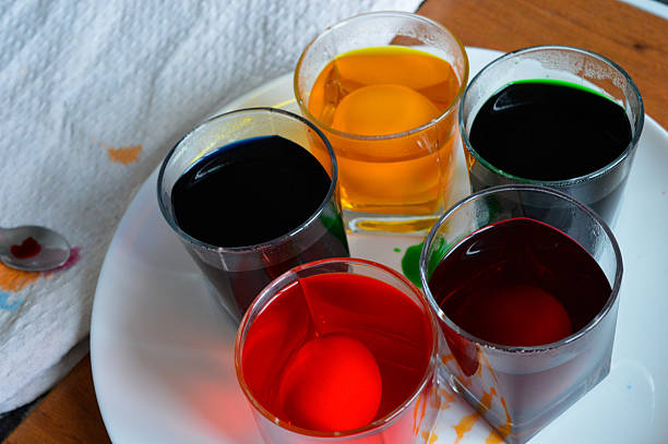 egg being dyed in a vibrant liquid hand carefully lifts the egg with a spoon process of Easter egg coloring holiday designs DIY crafting tutorials food creative cooking family traditions celebrations