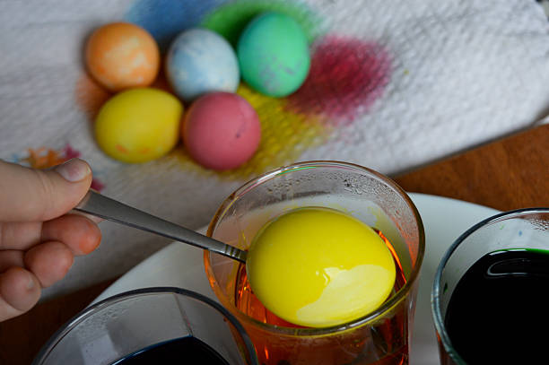 Colorful handmade painted Easter eggs on the yellow background.