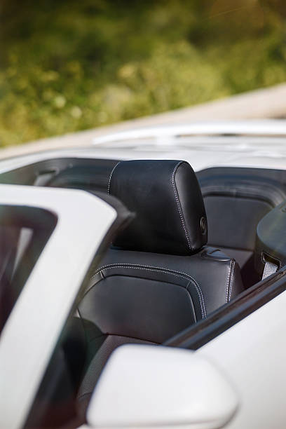 istock Convertible car interior featuring black leather seats, headrests and white stitching. Outdoor closeup in bright sunny daylight, ideal for automotive, luxury, travel projects. 2208356548