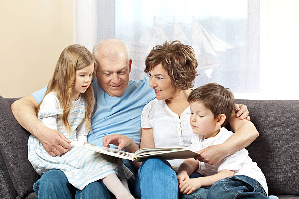istock Grandparents with grandchildren reading book 2208362445