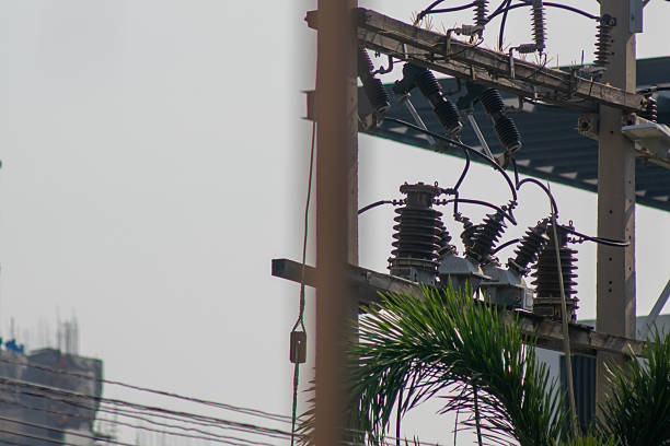 Urban power lines and electrical equipment shown against a cloudy backdrop. The image captures the essence of modern energy infrastructure in a city.