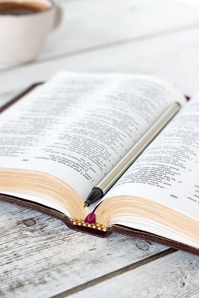 istock Open holy bible book with pen and cup of coffee 2208366006