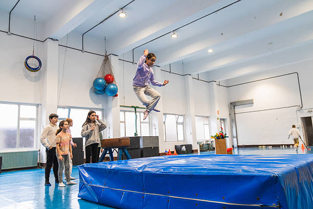 istock Students jumping on crash mat in school gym 2208367405