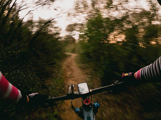istock Racing fast a mountain bike with a navigator in its handlebar on a forest single track cyclist point of view 2208367495
