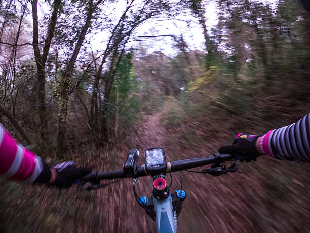 istock Racing fast a mountain bike with a navigator in its handlebar on a forest single track cyclist point of view 2208367587