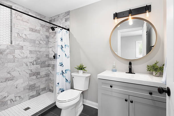 istock A bathroom with a grey cabinet, white sink, and tiled shower. 2208368160