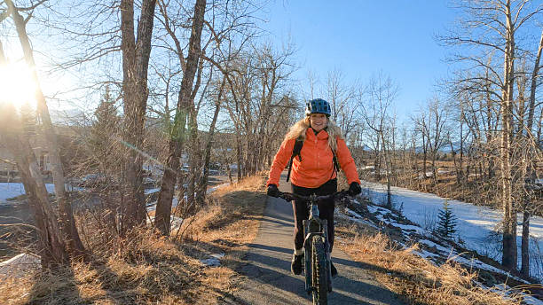 istock Mature woman e-bikes along pathway in mountains 2208370964