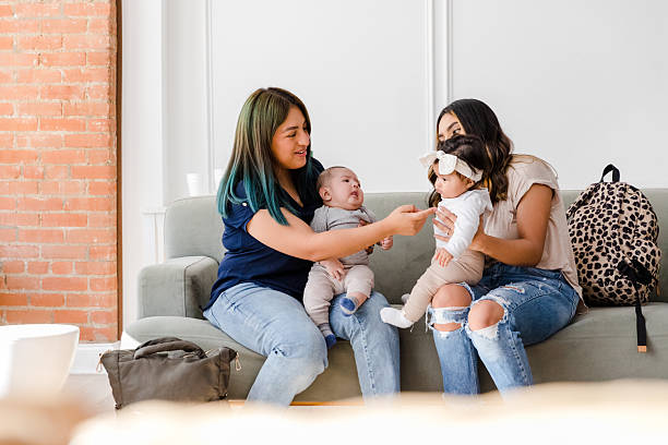 istock Two Young Mothers Bonding with Their Babies on a Sofa 2208371151