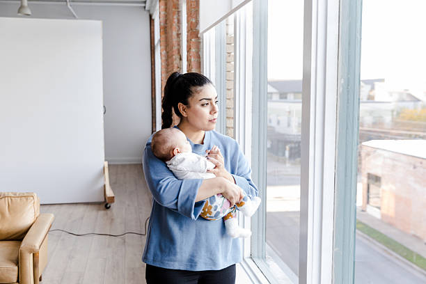istock Mother Holding Baby, Looking Out Window, Day Light 2208371174