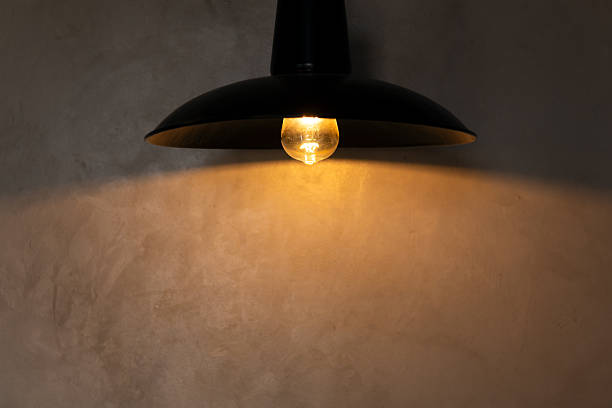 istock Concrete wall with warm light from black lamp 2208372469