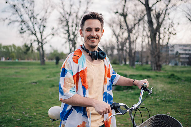 istock Young stylish man walking with his bicycle in a park 2208372894