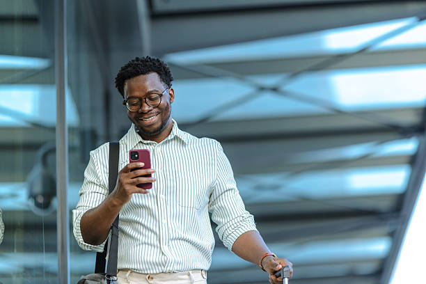 istock Businessman checking smartphone by window on public location 2208373207