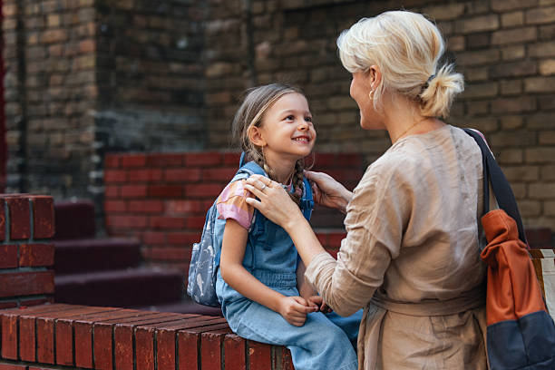 istock Mother Encouraging Daughter Ready for School Outdoors in Urban Setting 2208374658