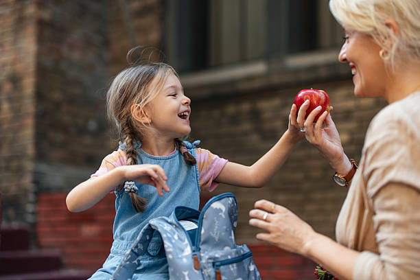 istock Mother and Daughter Sharing a Joyful Moment with an Apple Outside 2208374675