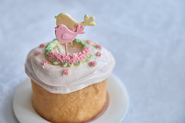 Resplendent, springtime happiness overflows from this beautifully baked Kulchichi Easter cake, adorned with a delicate bird and floral frosting, evoking tradition and renewal.