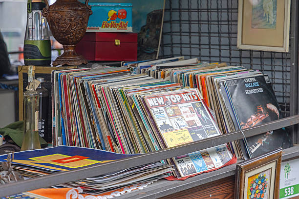 In a vinyl record store, an unrecognizable young woman sifts through neatly organized album covers, eagerly looking for new and exciting music to purchase for her collection.